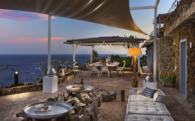 Lounge and dining terrace overlooking the sea at sunset