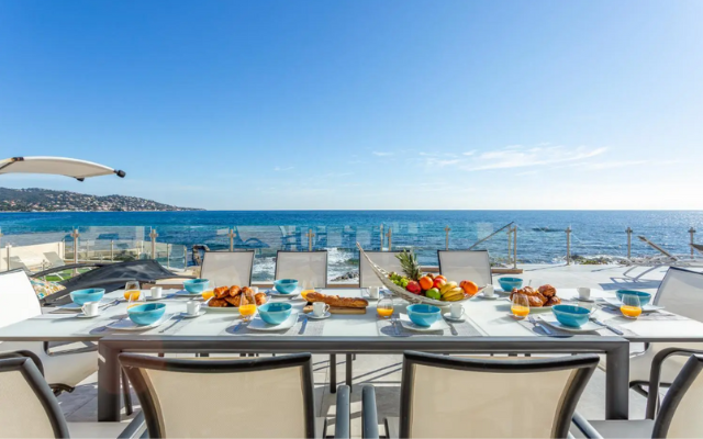 Dining table on terrace with fruit and juices overlooking the ocean