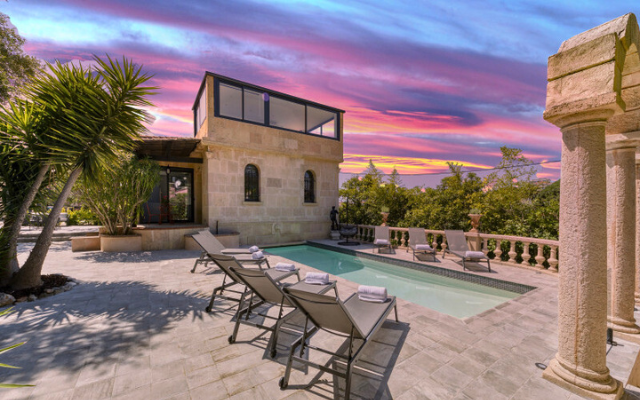 Villa with private pool against a multi-colored sunset